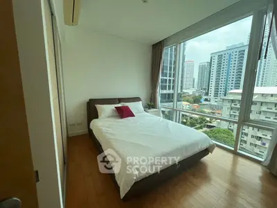 Modern bedroom with large windows offering stunning city views