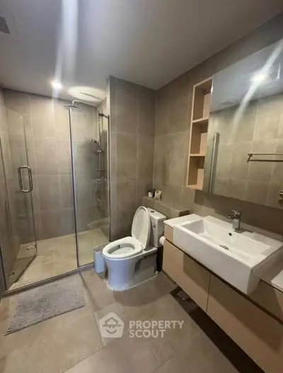 Modern bathroom with glass shower and sleek fixtures in a contemporary apartment.