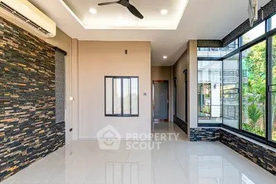 Modern living room with large windows and stylish stone accent wall
