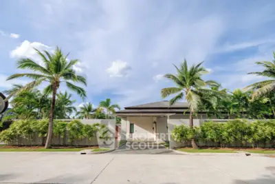 Luxurious tropical villa with palm trees and modern architecture, perfect for serene living.