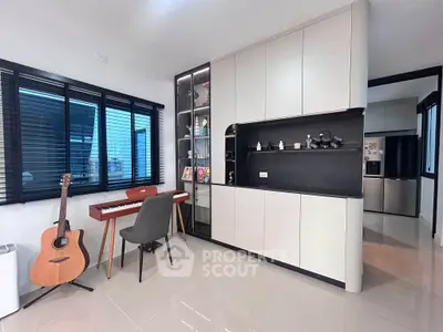 Modern living room with sleek cabinetry, musical instruments, and large windows for natural light.