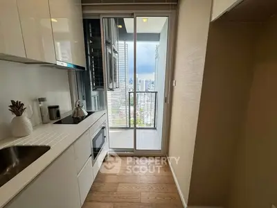 Modern kitchen with sleek cabinets and city view from balcony.