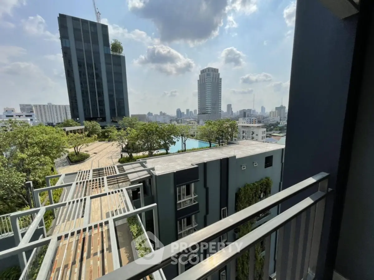 Stunning cityscape view from a modern balcony overlooking lush greenery and urban skyline.