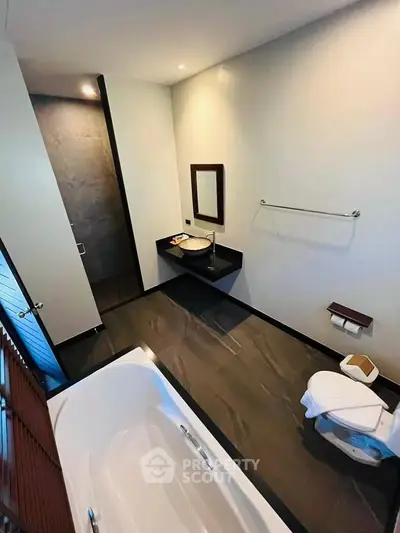 Modern bathroom with sleek design featuring a bathtub and stylish fixtures.