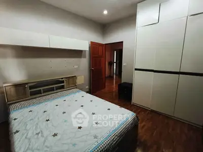 Spacious bedroom with modern wardrobe and wooden flooring