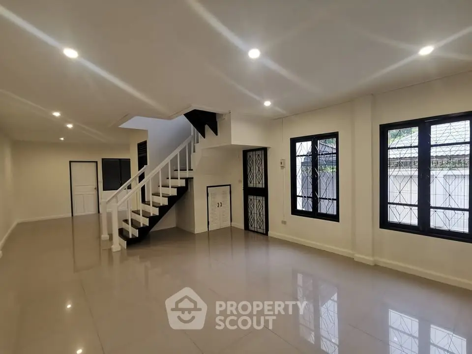 Spacious modern living room with sleek staircase and large windows