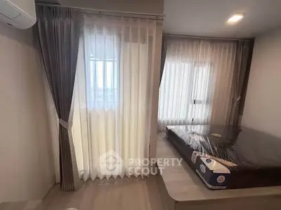 Modern bedroom with large windows and stylish curtains, featuring a neatly made bed and sleek flooring.
