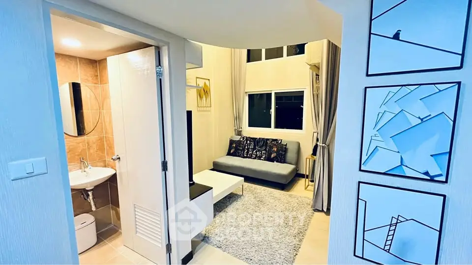Modern living room with cozy sofa and stylish decor adjacent to compact bathroom.