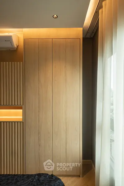 Modern bedroom with sleek wooden wardrobe and large window view
