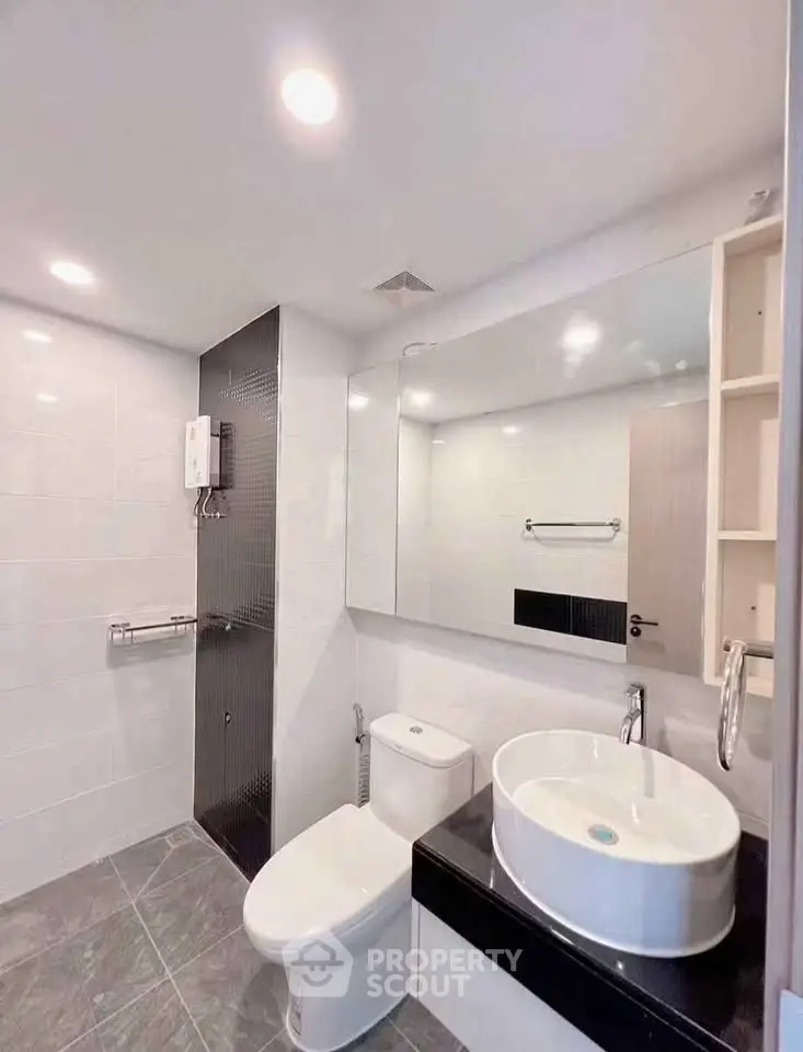 Modern bathroom with sleek fixtures and large mirror in a contemporary apartment.