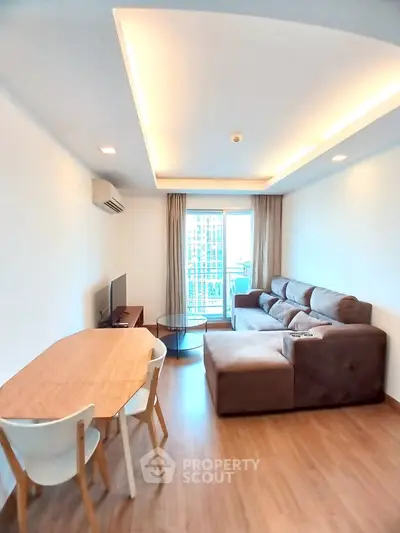 Modern living room with cozy sofa and dining area, featuring a city view from the window.