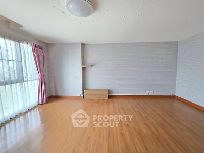 Spacious empty living room with wooden flooring and large windows