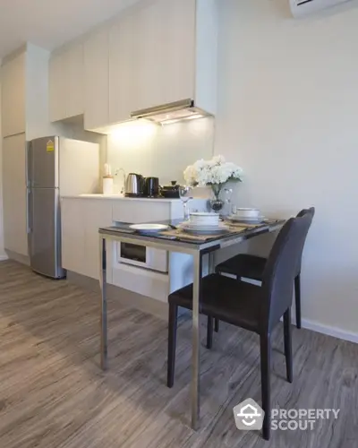 Modern kitchen with sleek cabinetry and dining area in stylish apartment