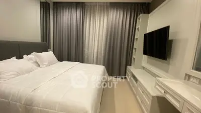 Modern bedroom with elegant curtains and wall-mounted TV, perfect for relaxation and comfort.