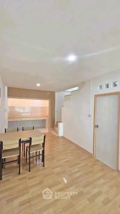 Spacious open-plan living area with modern dining set and stylish staircase