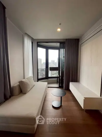 Modern living room with city view, featuring sleek furniture and floor-to-ceiling windows.
