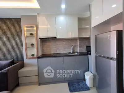 Modern kitchen with sleek cabinetry and stainless steel appliances in a stylish apartment.