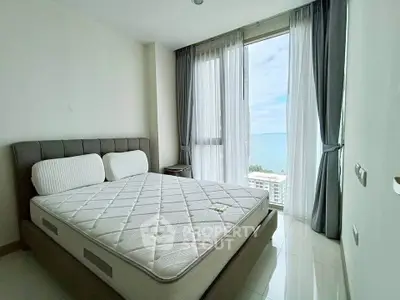 Bright bedroom with ocean view and modern furnishings in a high-rise apartment.