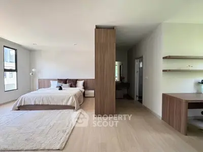 Spacious modern bedroom with elegant wooden accents and natural light