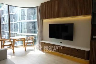 Modern living room with floor-to-ceiling windows and stylish wooden furniture