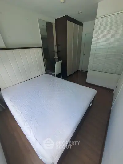 Modern bedroom with sleek design and ample natural light, featuring a comfortable bed and stylish furnishings.
