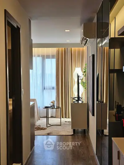 Stylish modern apartment hallway leading to a cozy living area with elegant decor.
