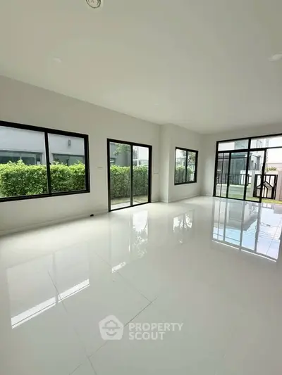 Spacious modern living room with large windows and garden view, perfect for natural light lovers.
