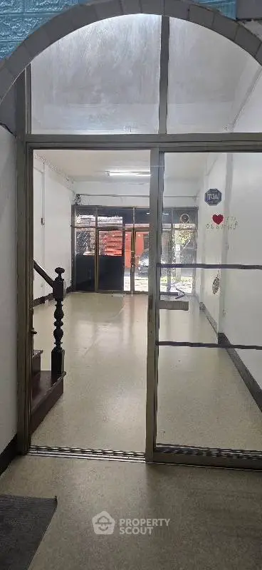 Spacious entrance with glass doors and staircase in a commercial property