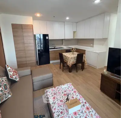 Modern open-layout living room with kitchen, featuring stylish furniture and city view.