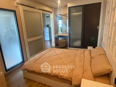 Cozy bedroom with modern decor and sliding doors in a stylish apartment.