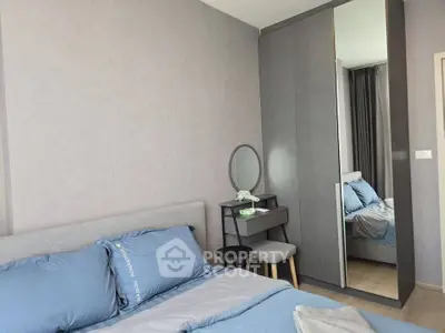 Modern bedroom with stylish decor and mirrored wardrobe in a cozy apartment.