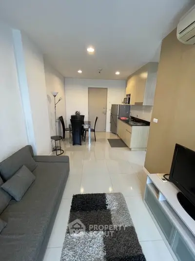 Modern living room with open kitchen layout, stylish furniture, and cozy ambiance.