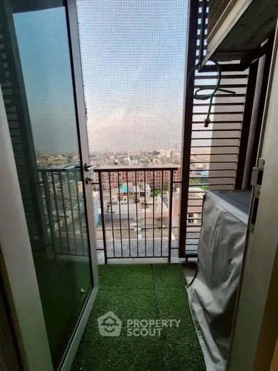Charming balcony with artificial grass and city view, perfect for relaxation and enjoying urban scenery.