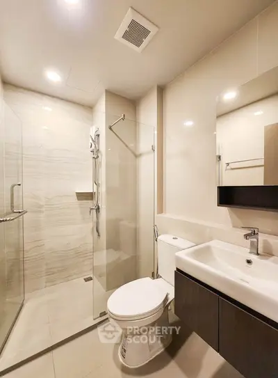 Modern bathroom with glass shower and sleek fixtures in a contemporary apartment.
