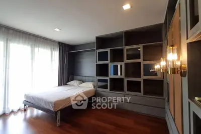 Spacious bedroom with modern built-in storage and large windows for natural light.
