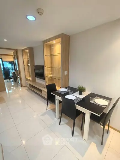 Modern dining area with sleek furniture and built-in display cabinets in a stylish apartment.