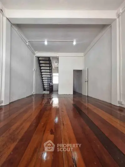 Spacious interior with polished wooden floors and staircase, ideal for modern living.