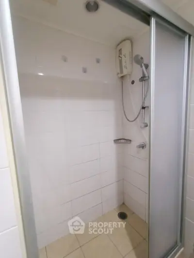 Modern bathroom shower with sliding glass doors and white tiles