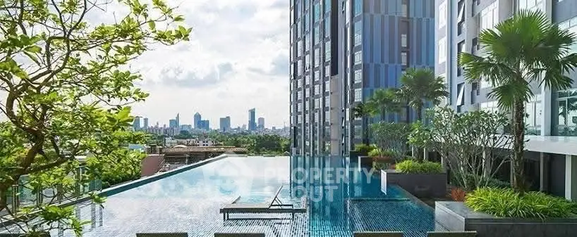 Luxurious rooftop pool with stunning city skyline view in modern high-rise building.