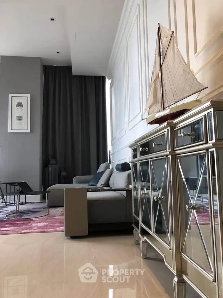 Luxurious living room with elegant decor and mirrored furniture, featuring a stylish sofa and decorative sailboat model.