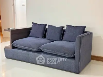 Modern blue sofa in stylish living room with sleek design and cozy cushions.