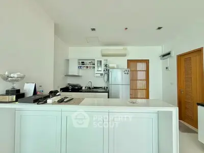 Modern kitchen with sleek white cabinetry and appliances in a bright, open layout.