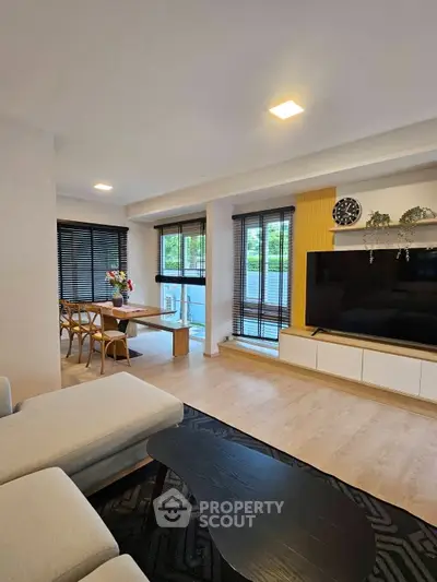 Spacious modern living room with stylish decor and large windows offering natural light.