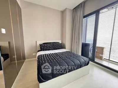 Modern bedroom with large window and stylish decor in a high-rise apartment.