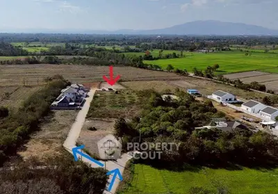 Aerial view of countryside property with house, driveway, and scenic landscape.