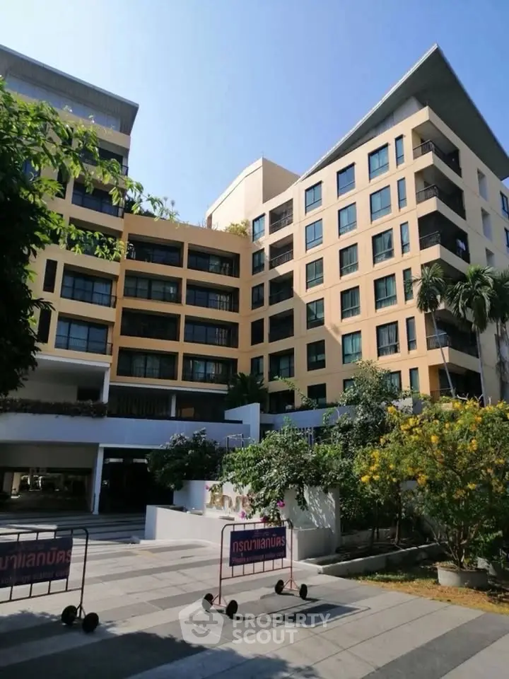 Modern apartment building with lush landscaping and spacious outdoor area.