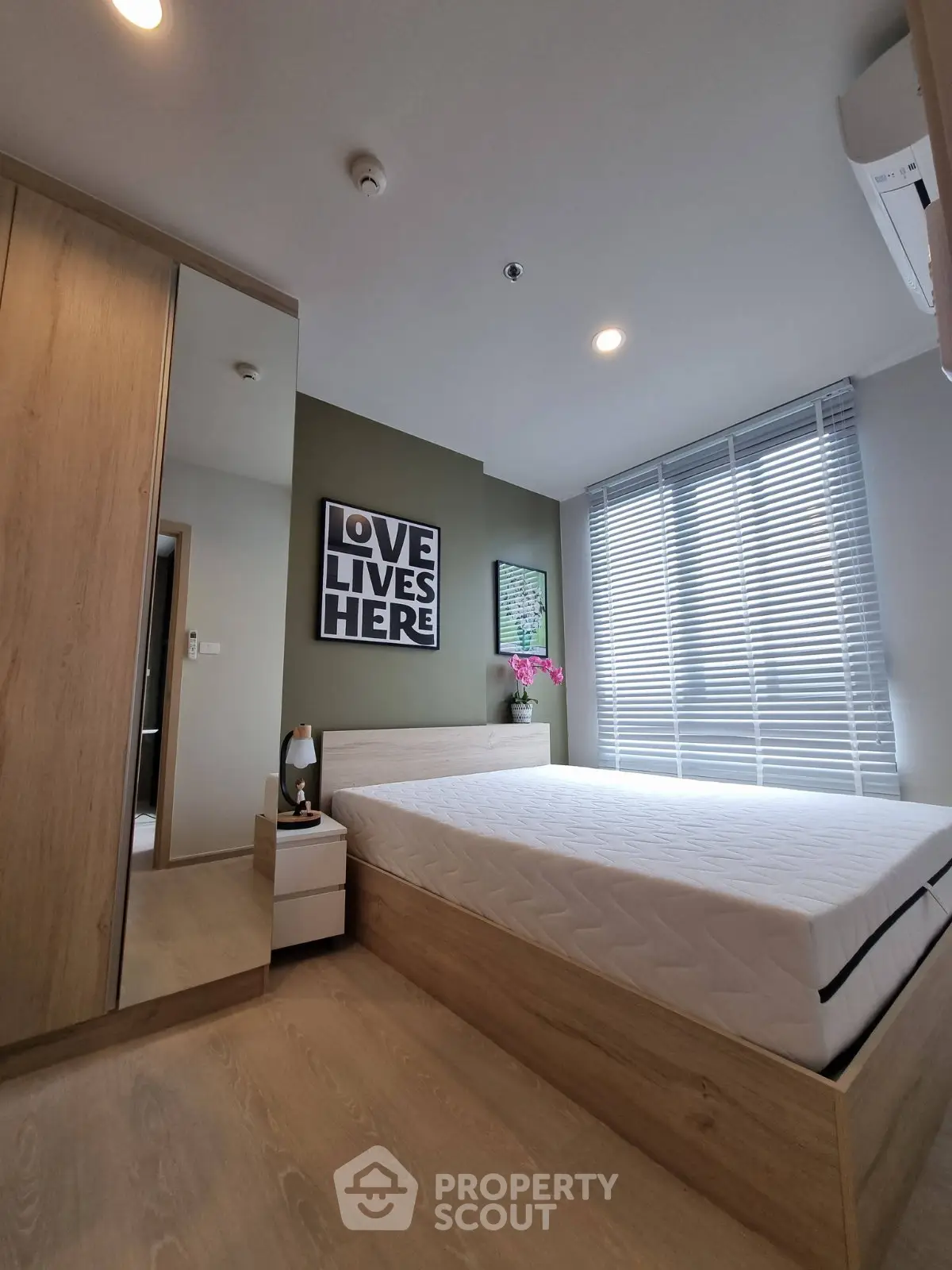Modern bedroom with stylish decor and natural light, featuring a comfortable bed and sleek wooden furniture.