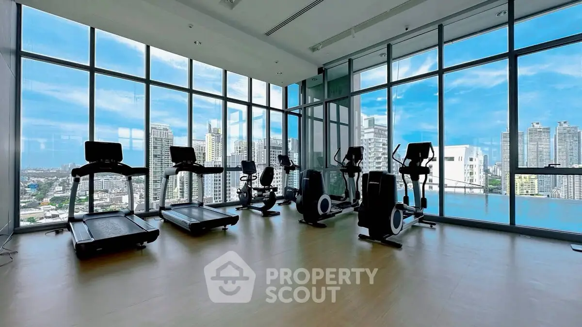 Luxurious high-rise gym with panoramic city views and modern fitness equipment.