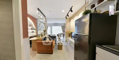 Modern open-plan living room with stylish decor and sleek kitchen appliances.
