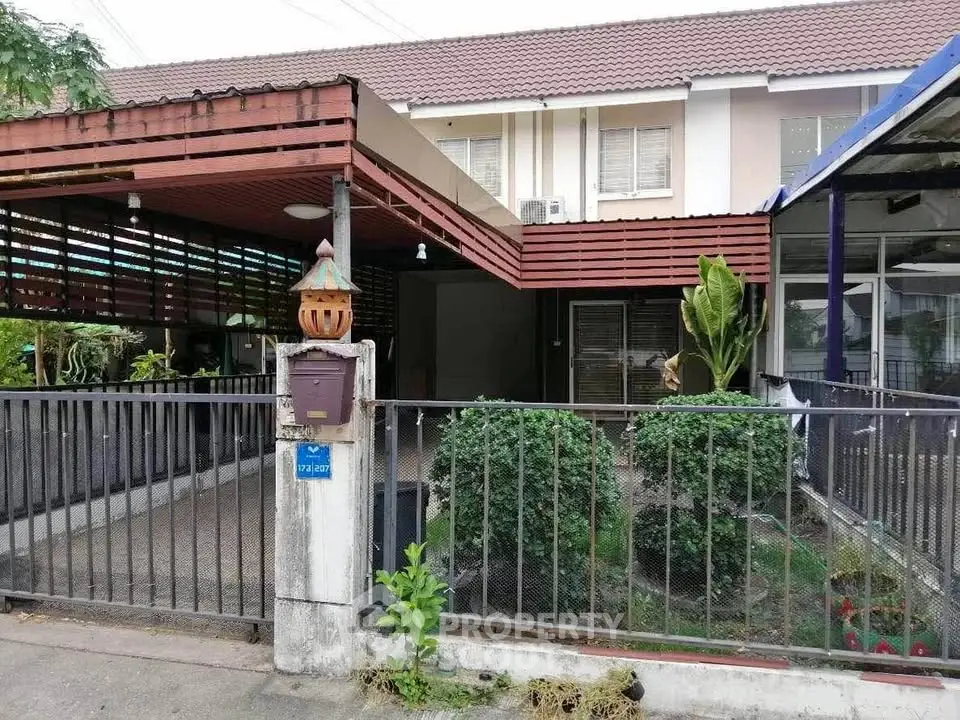 Charming townhouse with covered carport and lush garden in a serene neighborhood.